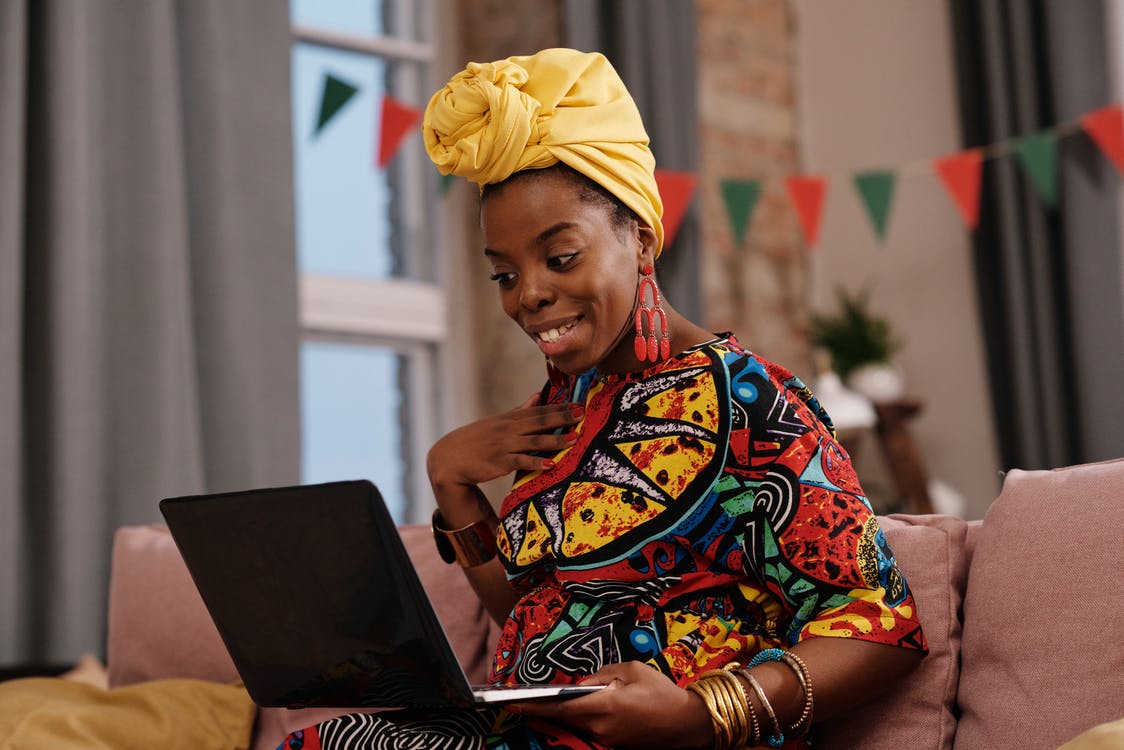 Femme noire souriante travaillant sur son ordinateur